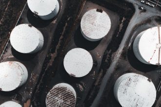 Vista aérea de grandes tanques industriais de armazenamento de combustíveis.