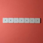 Letras formando a palavra “PRIVACY” sobre fundo vermelho, simbolizando proteção da privacidade e dos dados pessoais.