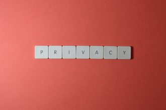Letras formando a palavra “PRIVACY” sobre fundo vermelho, simbolizando proteção da privacidade e dos dados pessoais.