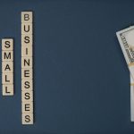 Composição conceitual com dinheiro e peças com letras representando apoio financeiro a pequenos negócios.